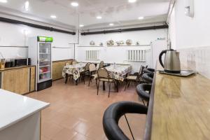 a dining room with a table and chairs and a refrigerator at Light Hostel by TripLE in Yakkasaray