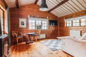 a living room with a table and chairs at Rustic Nordic Getaway by the Sea in Axmar