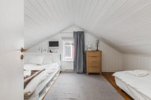 a attic bedroom with two beds and a window at Rustic Nordic Getaway by the Sea in Axmar