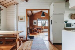 a kitchen with a table and a dining room at Rustic Nordic Getaway by the Sea in Axmar