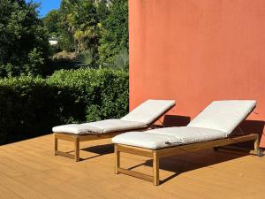 two lounge chairs sitting next to a wall at LA CALETTA SUITE APARTMENT- Panoramic Shared Pool, Secured Parking, Water Activities in Blevio