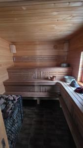 a sauna with a bench in a wooden room at Ramaus poilsio sodyba in Petruniškis