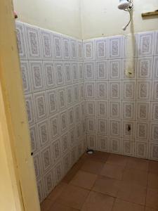 a room with white walls and white tiles at Next Level in Gulu