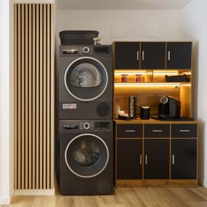 two washing machines are stacked next to a kitchen at CT Executive Rooms, Lake Como and Valtellina in Dubino