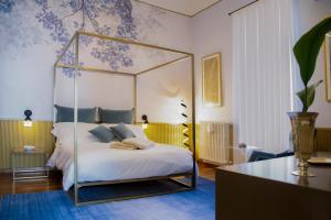 a bedroom with a canopy bed with a blue patterned wall at Rose Iconic Rooms in Lecce