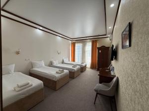 a hotel room with three beds and a table at Hotel Khiva Palace in Khiva