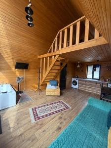 a large room with a wooden ceiling with a staircase at Guesthouse Elli & Cottages in Kazbegi