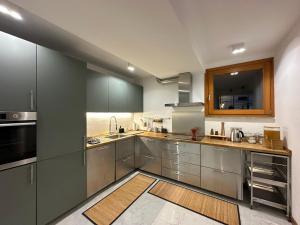 a large kitchen with stainless steel cabinets and stainless steel appliances at LA CALETTA SUITE APARTMENT- Panoramic Shared Pool, Secured Parking, Water Activities in Blevio