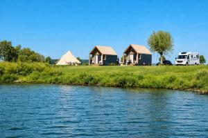 a group of houses next to a river at Luxury Suite in Heerewaarden