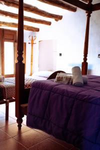 a bedroom with a bed with a purple blanket at Finca Vitoria in Moratalla