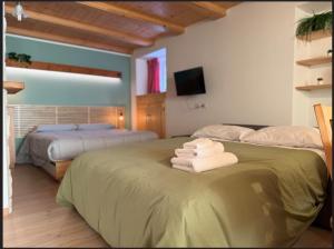two beds in a room with towels on a bed at Dolomiti Nest in Tesero +16 photos
