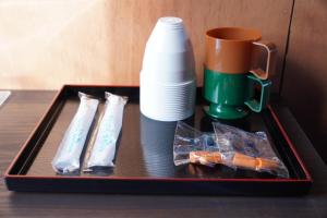 a tray with a coffee mug and a cup on a table at 灯GuestHouse in Aizuwakamatsu