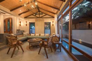 a living room with a couch and a table and chairs at Anjuna Casa Nova in Jāmb