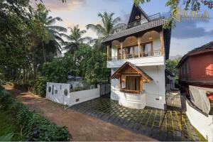 a large white house with a balcony on top of it at Anjuna Casa Nova in Jāmb