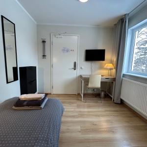 a bedroom with a bed and a desk and a window at Wallamaja Hostel in Järvakandi