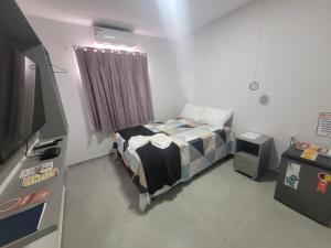 a small bedroom with a bed and a television at Pousada Novo Millenium in Araripina