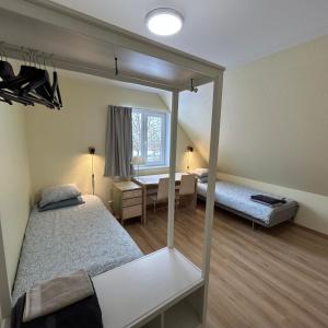 a room with two beds and a desk and a window at Wallamaja Hostel in Järvakandi