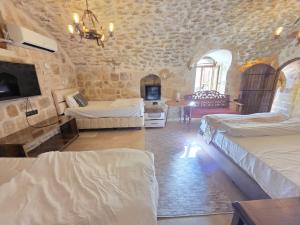 a bedroom with two beds in a room with stone walls at Babussor konağı hotel in Eskiömerler