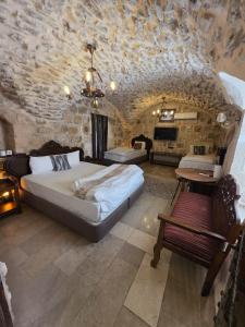 a bedroom with a large bed and a stone wall at Babussor konağı hotel in Eskiömerler