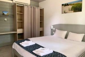 a bedroom with a bed with towels on it at Camping les Criques de Royan in Saint-Georges-de-Didonne +28 photos