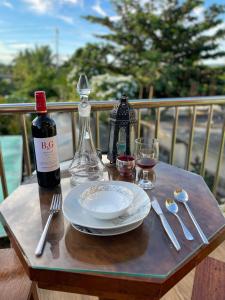 a table with a bottle of wine and a plate and glass at B2-B Guesthouse in Guiuan