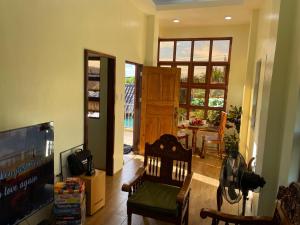 a living room with a television and a dining room at B2-B Guesthouse in Guiuan