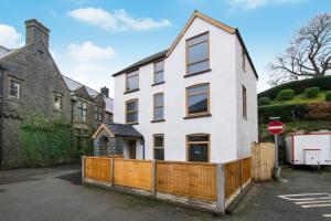 a white house with a wooden fence in a parking lot at 5 Bed in Bala oc-bow163 in Bala