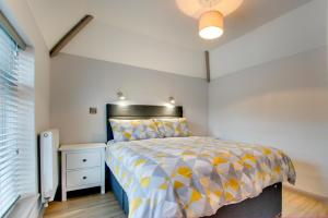 a bedroom with a bed with a yellow and white comforter at 5 Bed in Bala oc-bow163 in Bala