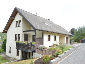 una casa blanca con techo negro en holiday home in xheim Niederehe with garden, en Niederehe