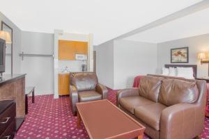 a hotel room with a couch and a table at Days Inn by Wyndham Lake Village in Lake Village