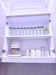 a shelf with glass jars and plates in a kitchen at Beytumn Executive Apartment in Ruiru +5 photos