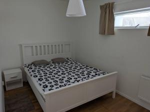 a bedroom with a bed with a black and white comforter at A charming countryside accommodation near Malm in Oxie