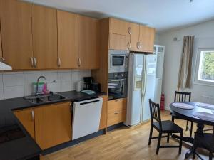 a kitchen with wooden cabinets and a table and a dining room at A charming countryside accommodation near Malm in Oxie