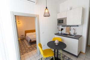 a kitchen with a table and yellow chairs in a room at La Dimora dei WaLori in Bisceglie