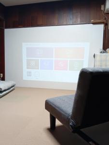 a large projection screen in a room with a couch at やぎみちの家 yagimichi-noie in Sasebo