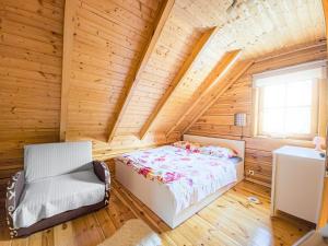 a bedroom in a log cabin with a bed and a chair at Domek z bali in Jarnołtówek