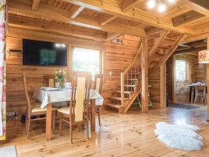 a dining room with a table in a wooden cabin at Domek z bali in Jarnołtówek