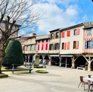 a group of buildings with red and white windows at Hôte Labyrinthe sur la place chambres d, hôtes , calme ,Netflix in Mirepoix