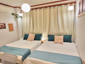 two beds in a room with curtains at 대구 K Stay in Daegu