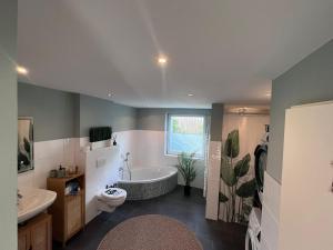 a bathroom with a tub and a toilet and a sink at Güden Pearl Bhaven Deck 6 ,Exklusive große Wohnung,Hochwertige Ausstattung,Privatparkplatz & Carport,Großer Garten mit Gartenhaus,Langzeitaufenthalt in Bremerhaven +66 photos