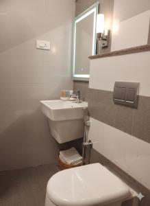 a bathroom with a white toilet and a sink at AR Residency Tnagar Chennai in Chennai +16 photos