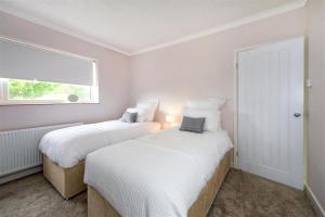 two beds in a white room with a window at 2 Bed in Pwllheli oc-45caed in Abersoch