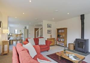 a living room with a red couch and a stove at 2 Bed in Leiston oc-cqa in Theberton