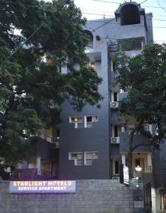 a tall building with a sign in front of it at AR Residency Tnagar Chennai in Chennai