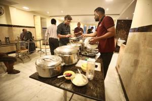 a group of people standing in a kitchen preparing food at AR Residency Tnagar Chennai in Chennai