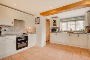 a kitchen with white cabinets and a tile floor at 3 Bed in Bodham oc-1638 in Bodham +15 photos