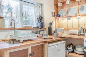 a kitchen with a sink and a counter with dishes at 1 Bed in Blakeney oc-674 in Blakeney +9 photos