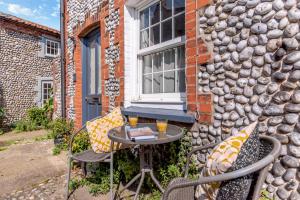 a patio with a table and chairs in front of a building at 1 Bed in Blakeney oc-674 in Blakeney