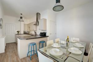 a white kitchen with a glass table and chairs at 3 Bed in Cromer oc-1727 in Cromer