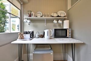 a small kitchen with a counter with a microwave at Finest Retreats - St Germains Annexe in Sandwich